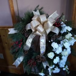 Fresh outside evergreen wreath with fresh flowers added to it for a sympathy piece.