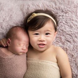 Jennifer McNeil Photography - Big sister and little sister comfy on a soft lamb rug