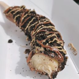 a chocolate covered banana on a white plate a chocolate covered banana on a white plate