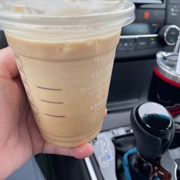 a hand holding a cup of iced coffee a hand holding a cup of iced coffee