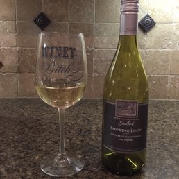 a glass of white wine next to a bottle of wine