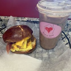 Brooke's House Coffee and Chocolate - Bacon, egg and cheese sandwich on a pretzel bun with an iced mocha latte.