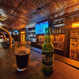 a beer and a glass on a bar a beer and a glass on a bar