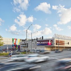 Fashion Outlets of Chicago - Fashion Outlets of Chicago exterior beside a busy roadway under a blue sky.