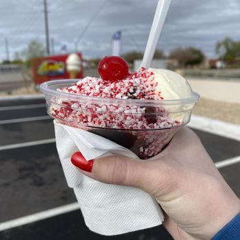 Andy's Frozen Custard - a hand holding a cup of ice cream with a cherry on top - Desserts Near Me - Mesa, Arizona