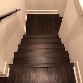 Flooring Genius - a set of wooden stairs - General Contractors Near Me