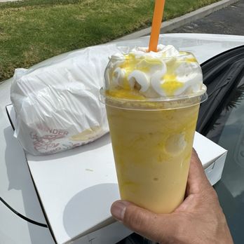 Donut Express - Mango smoothie with yummy wrapped sandwiches in the background. - Bagels Near Me - Buena Park, California