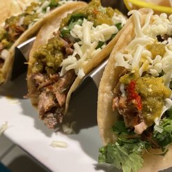 El maya style carnitas tacos on corn tortillas with shredded cheese is a winner!