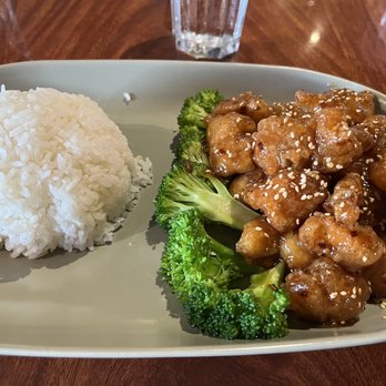 Wild Basil Restaurant - Sesame chicken - A plate with sesame chicken garnished with sesame seeds, broccoli, and a mound of white rice. - Thai Near Me - Littleton, Colorado