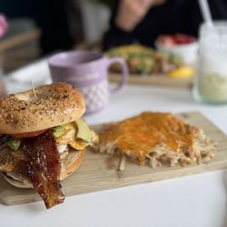 The Brunch Collective - Breakfast bagel sandwich add avocado. Cheesy hash browns side. So good!