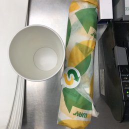 a cup of coffee and a paper towel on a table
