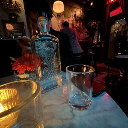 a glass of water and a bottle of gin a glass of water and a bottle of gin