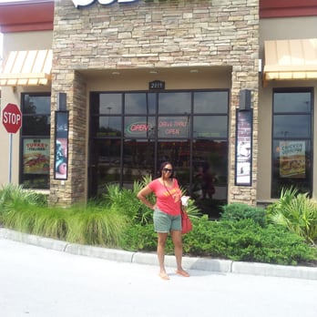 Subway - a woman standing in front of a subway restaurant - Sandwiches Near Me - Ocala, Florida