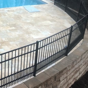Premium Lawn & Landscaping - closeup of Travertine pool deck, aluminum fence and 3 retaining walls - Irrigation Near Me Premium Lawn & Landscaping - closeup of Travertine pool deck, aluminum fence and 3 retaining walls - Irrigation Near Me