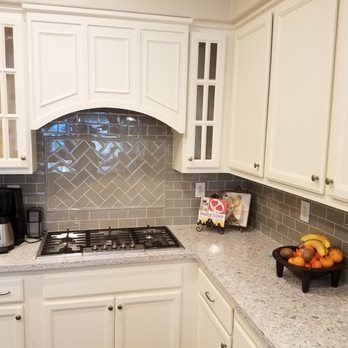 JRD Construction - a kitchen with white cabinets and granite countertops - General Contractors Near Me