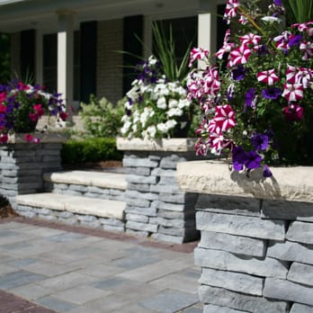 Michigan Landscape Design Services - a stone planter with purple and white flowers - Landscaping Near Me - Plymouth, Michigan Michigan Landscape Design Services - a stone planter with purple and white flowers - Landscaping Near Me - Plymouth, Michigan