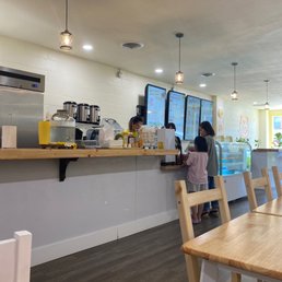 a woman standing at a counter in a coffee shop