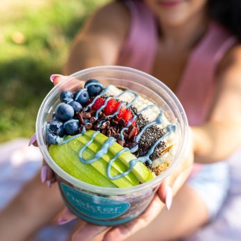 Nekter Juice Bar - a woman holding a bowl of fruit - Juice Bars & Smoothies Near Me - Surprise, Arizona Nekter Juice Bar - a woman holding a bowl of fruit - Juice Bars & Smoothies Near Me - Surprise, Arizona