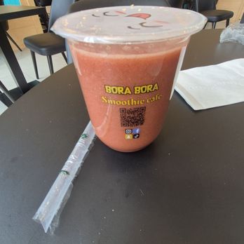 Bora Bora - A pinkish smoothie in a clear plastic cup with a straw, placed on a black table at Bora Bora Smoothie Cafe in The Bronx. - Acai Bowls Near Me - The Bronx, New York