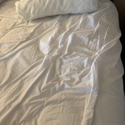 Unmade bed when covered were pulled back Unmade bed when covered were pulled back
