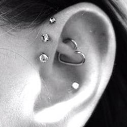 Triple forward helix, rook, and conch piercings.