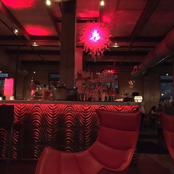 Battalion - Lounge area facing the bar on the first floor. Modern, red chairs & red-lighting theme. - Italian Near Me - San Antonio, Texas