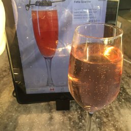 a glass of rose wine next to a menu a glass of rose wine next to a menu