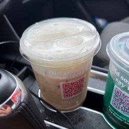 a cup of coffee and a drink in a cup holder a cup of coffee and a drink in a cup holder