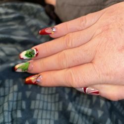 Tiny's Nails & Spa - The gas ch in a want hat and beard and also grinch holding a tree ornament on middle finger