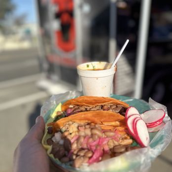 Tacos El Menny - a person holding a plate of food - Street Vendors Near Me Tacos El Menny - a person holding a plate of food - Street Vendors Near Me