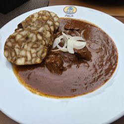 Švejk restaurant "U Pětatřicátníků" - Goulash Otto Katze prepared on black beer served with bacon dumplings, onions and pepperoni