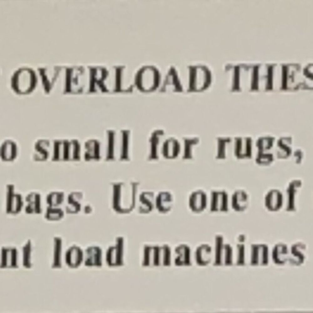 Sign in the laundromat advising to use the larger washers rugs and blankets. Sign in the laundromat advising to use the larger washers rugs and blankets.