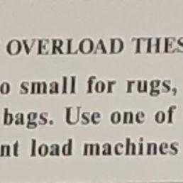 Sign in the laundromat advising to use the larger washers rugs and blankets.