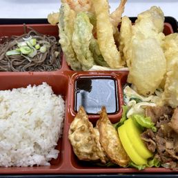 Lunch bento with pork, soba, dumplings, macaroni salad and a combination tempura Lunch bento with pork, soba, dumplings, macaroni salad and a combination tempura