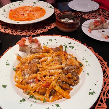 Bruschetta Francesca - Penne pasta with mushrooms and sausage.  With lobster ravioli in the background and complimentary house made bruschetta on the right. - Italian Near Me - Key West, Florida