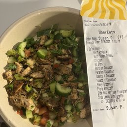 a salad in a bowl with a receipt
