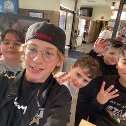 Sincerely, from the boys - A group of five boys pose for a selfie inside a fast-food restaurant, with a counter and menu visible in the background.
