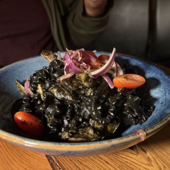 Fattoria E Mare - The squid ink seafood pasta. The seafood is there! Mussels, calamari and shrimp. The tomatoes and sliced onions is a great addition. - Italian Near Me - Half Moon Bay, California