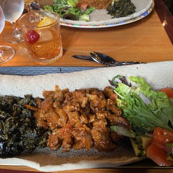 Black Garlic - Lamb bits, collards, salad with a house old fashioned. - Caribbean Near Me - Kansas City, Missouri