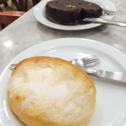Primer plano de bollo de leche y palmera de chocolate al fondo.