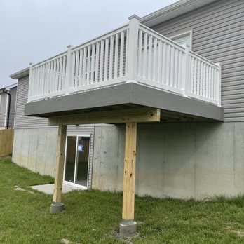 Prodecks - a house with a deck and a trash can - General Contractors Near Me