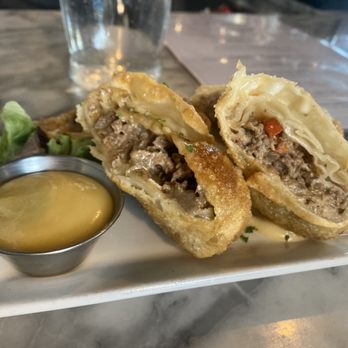 The Oysterman - Oysterman Egg Rolls -- seared steak, american and cheddar cheese, peppers, onions, maple dijon dipping sauce - Seafood Near Me - Duxbury, Massachusetts The Oysterman - Oysterman Egg Rolls -- seared steak, american and cheddar cheese, peppers, onions, maple dijon dipping sauce - Seafood Near Me - Duxbury, Massachusetts