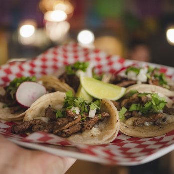 Bravo Restaurant - a hand holding a plate of tacos - Mexican Near Me - Calgary, Alberta Bravo Restaurant - a hand holding a plate of tacos - Mexican Near Me - Calgary, Alberta