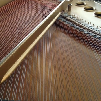 Piano Expectations - A view of the soundboard, bass and tenor strings, and caste iron plate (painted gold). - Piano Services Near Me