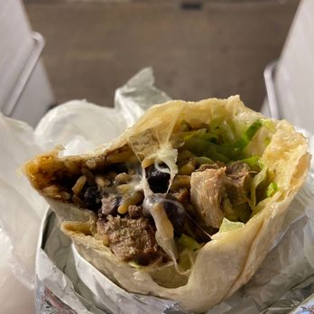 Morelos Authentic Mexican Cuisine - a hand holding a burrito - Mexican Near Me Morelos Authentic Mexican Cuisine - a hand holding a burrito - Mexican Near Me