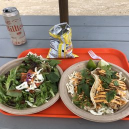 two plates of food on a picnic table two plates of food on a picnic table
