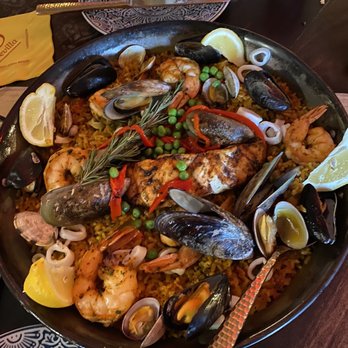 Cafe Sevilla - Calamares Fritos ($9) Baked Manchego Cheese and Chorizo Empanda Duo ($9) Mushroom & Fig Coca ($9) Large Seafood Paella Mariners (Full $59) - Spanish Near Me - Costa Mesa, California