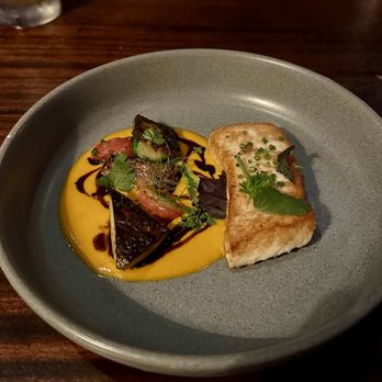 Gracie's - Atlantic halibut with heirloom tomato passata, summer squash, herbs, and black olive oil - New American Near Me - Providence, Rhode Island