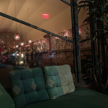 Bar Franca - a green couch with pillows in front of a window - Bars Near Me - Los Angeles, California