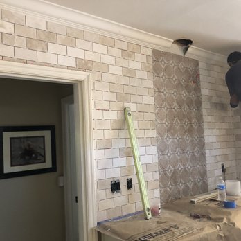 Stewart Tile - a man standing on a ladder in a kitchen - Flooring Near Me Stewart Tile - a man standing on a ladder in a kitchen - Flooring Near Me